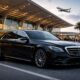 luxury sedan chauffeur car parked at airport terminal for premium airport limousine transfer service
