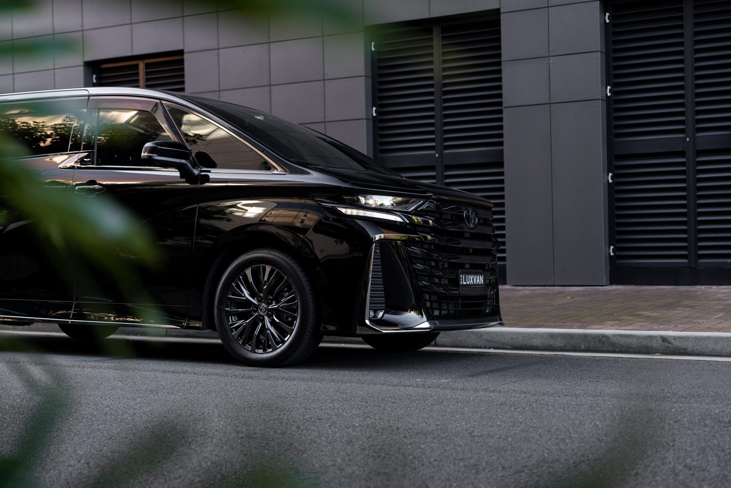 Front side view of a luxury Toyota Alphard chauffeur vehicle in Sydney for airport transfers, executive travel, VIP and family transportation.