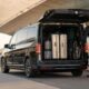 Luxury airport transfer vehicle with suitcases and a folded pram