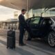 Professional chauffeur opening a luxury car at Sydney Airport